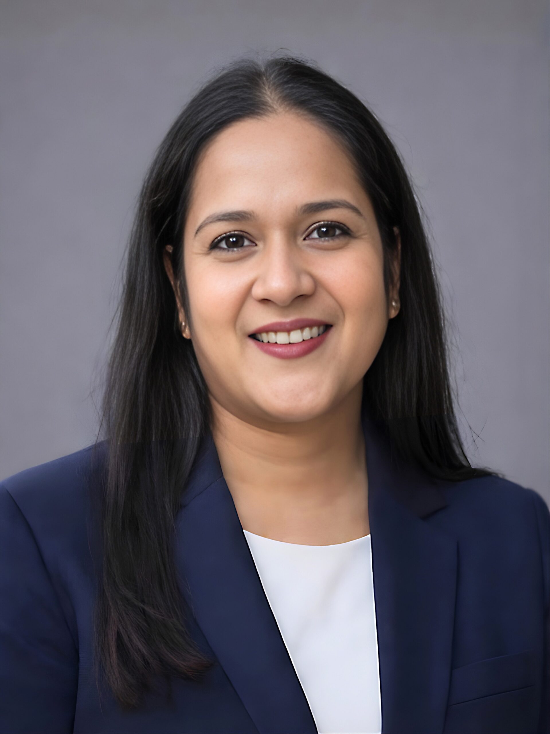 Image of a smiling woman in blue suit, white shirt
